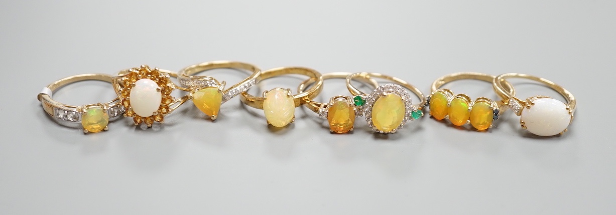 Seven assorted modern 9ct gold, opal and gem set dress rings, gross 14.6 grams and a 925 ring.